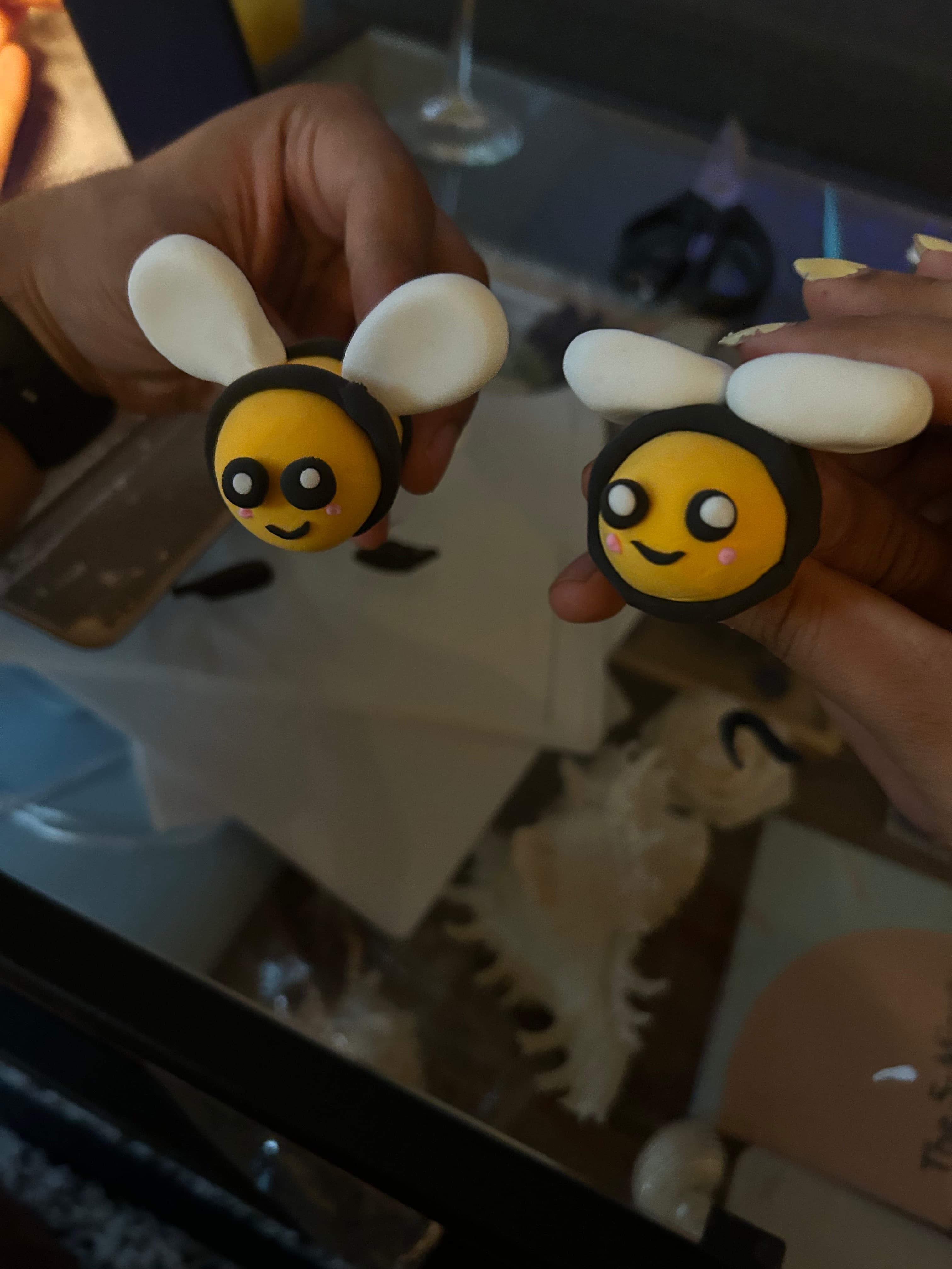 Two bee-shaped clay pieces